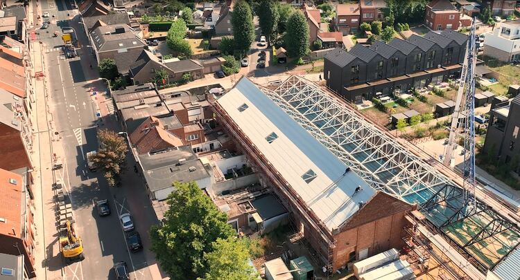 Bovenaanzicht van twee industriële loodsen die verbouwd worden.